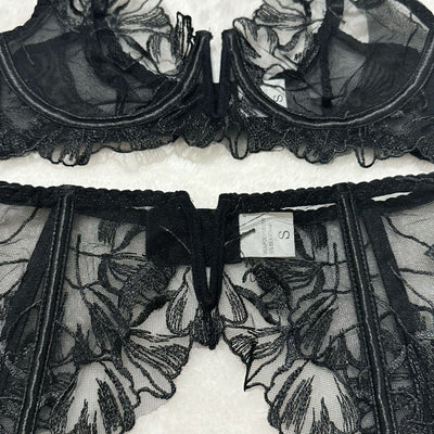 Black sheer floral lace lingerie set bra and garter belt panel with hook-and-eye closure.