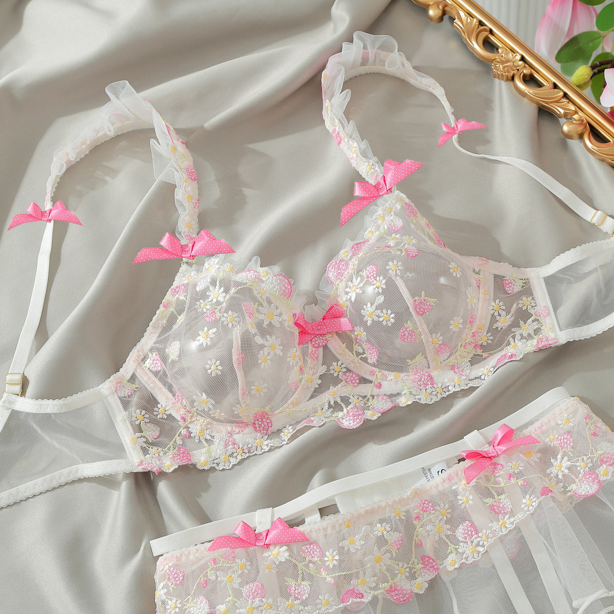 Pink floral embroidered mesh lingerie set with ruffled cups, lace trim, and bow details