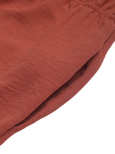 Rust-red draped fabric with soft texture