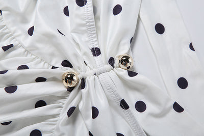 White polka-dot top with ruched front, drawstring, and gold button hardware