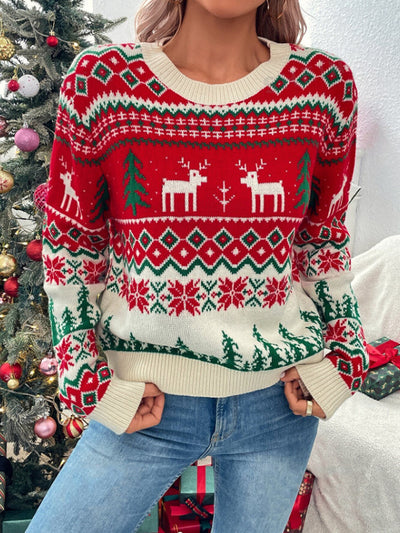 Close-up: Red knit reindeer sweater with green tree motifs and patterned yoke, ribbed hem