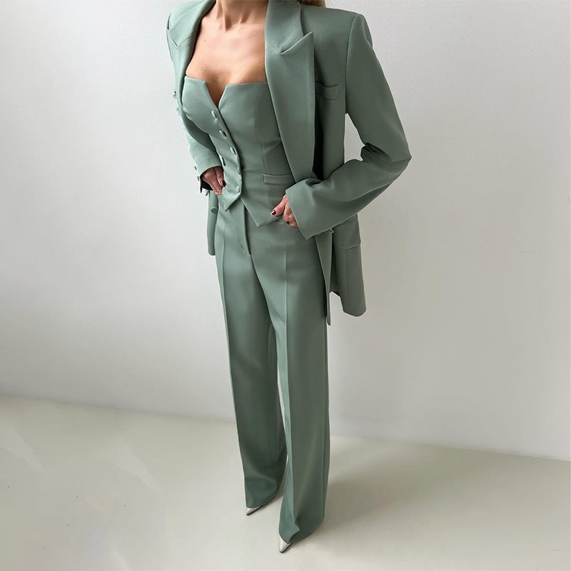 Three-piece suit set in muted green at an angle: blazer, button-front vest, wide-leg pants