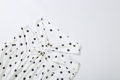 White polka-dot off-shoulder top with gathered neckline and gold button accents
