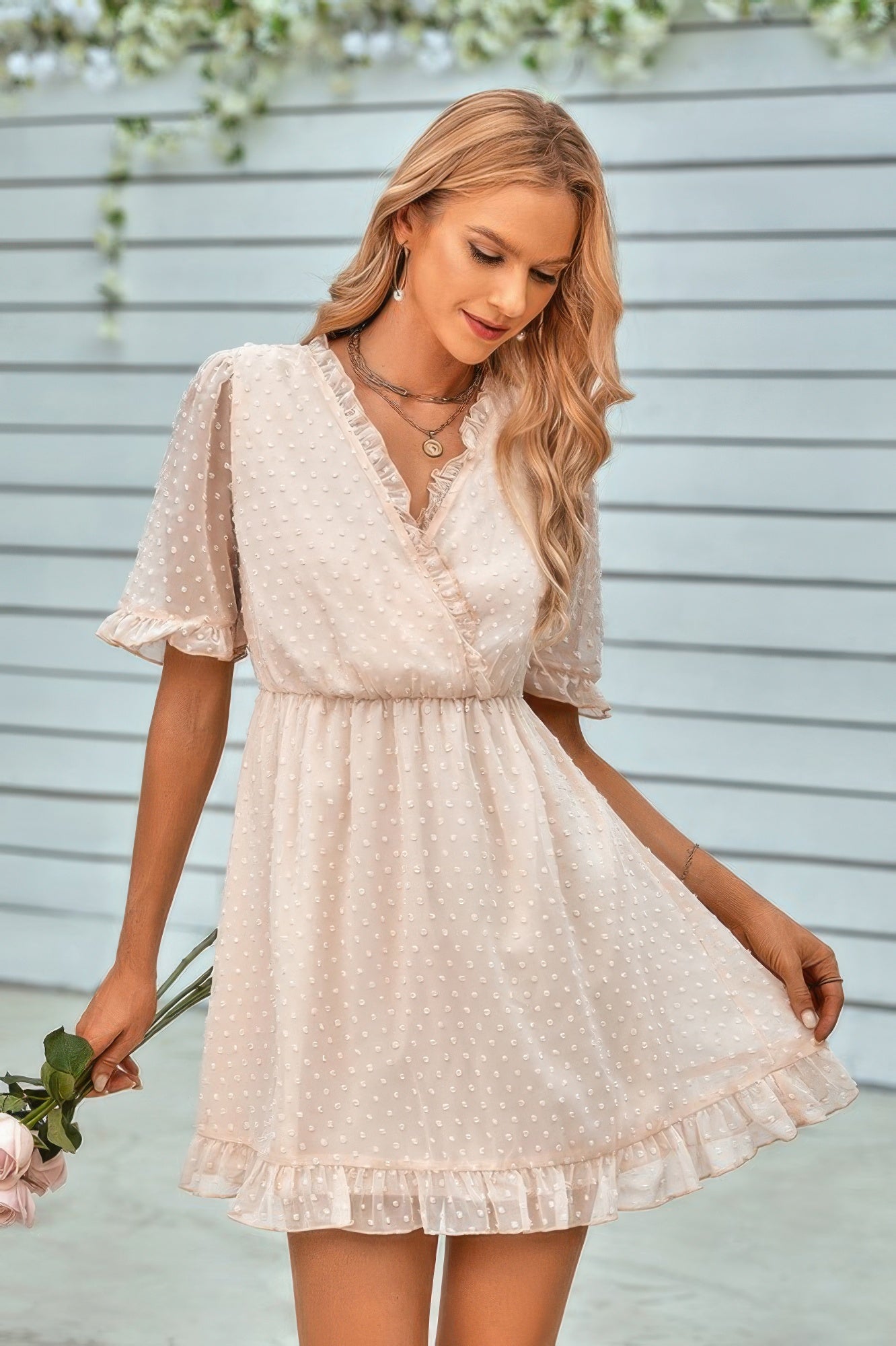 Model wearing a cream swiss dot ruffle midi dress with V wrap neckline, puff sleeves, elastic waist and ruffle hem