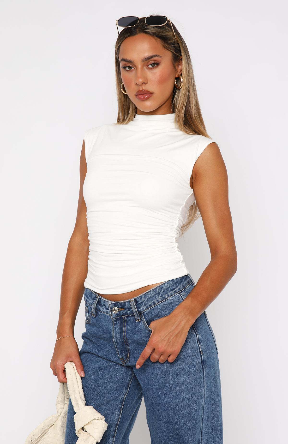 Ruched mock neck sleeveless tank top, white fitted design, front 3/4 view