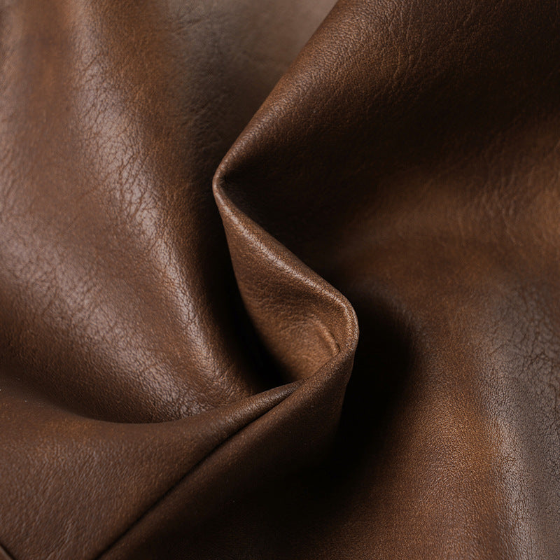Close-up of brown leather-look fabric texture on the shorts.