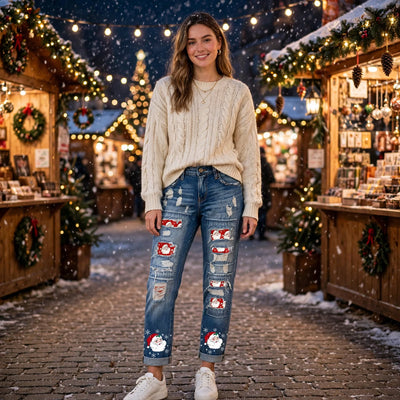 Blue distressed denim jeans with Santa patch panels and ripped detailing at knees