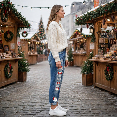Blue distressed denim jeans with Santa patch panels on both legs, distressed knees